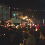 The torch runners going through the crowd to the police station.